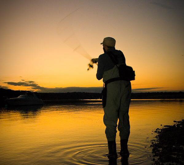 Saltwater fisherman casts his line at sunset.
