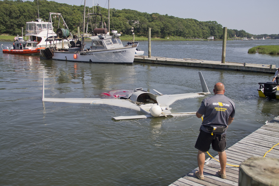 A Sea Tow helps pull the downed plane from water in Mattituck Inlet Monday afternoon. (Credit: Paul Squire) 