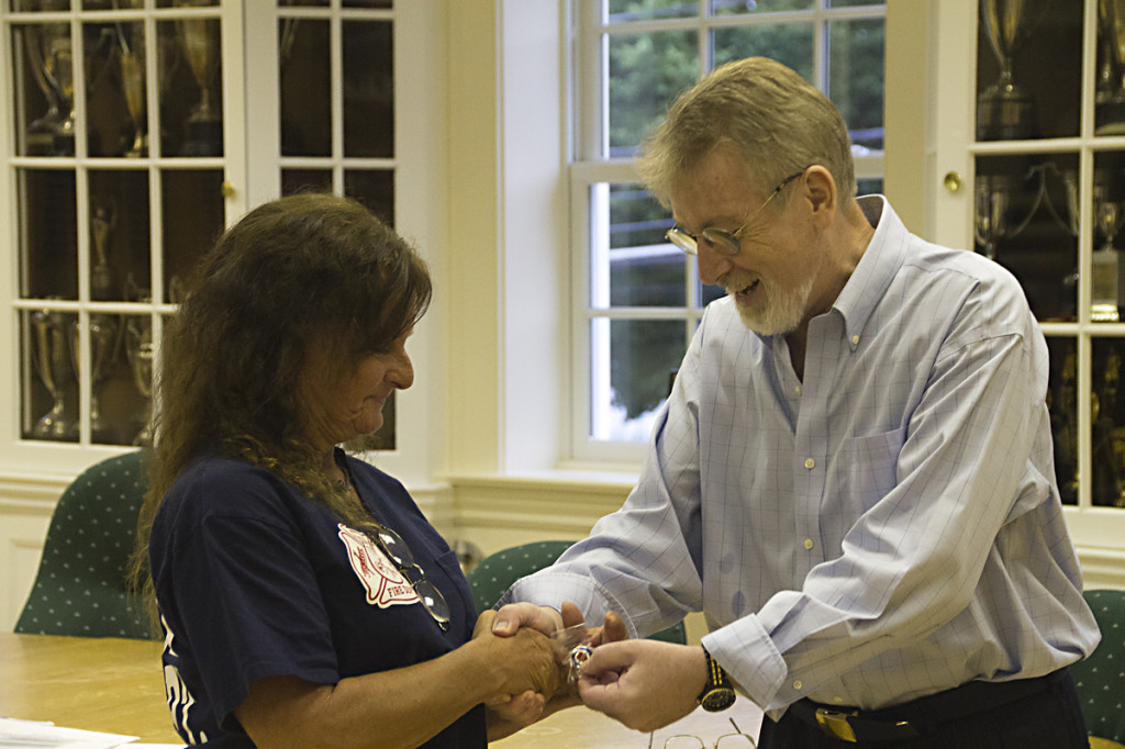 Heart attack survivor Joseph O'Byrne gives a special pin to Southold volunteer Renee Phelps, who performed CPR on Mr. O'Byrne and helped save his life in May. (Credit: Paul Squire)