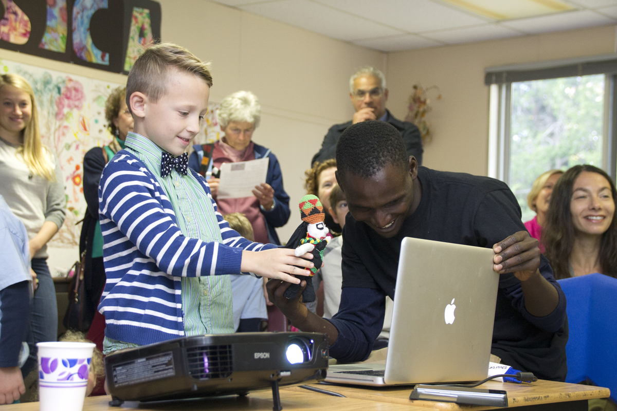 Peconic Community School lower primary student Sawyer Harbin shows the Zimbabwe schoolchildren the doll he bought during a live video conference Friday morning as Tinashe Basa, a nonprofit director, watches on. (Credit: Paul Squire)