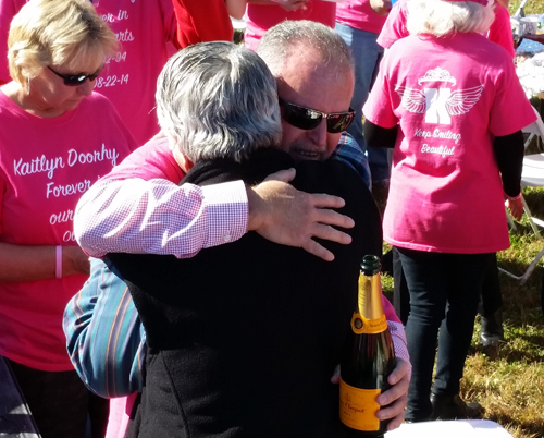 Kaitlyn's father, Joseph, wearing a pink memorial T-shirt, hugs Bill Araneo of Mattituck. (Credit: Greg Zuhoski photos)