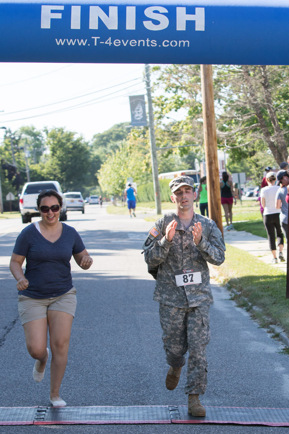 Organizer and U.S. Army veteran Josh Whaley crosses the finish line with his  fiancee, Alicia Idunate. He ran with a backpack filled with 40 pounds of weights.