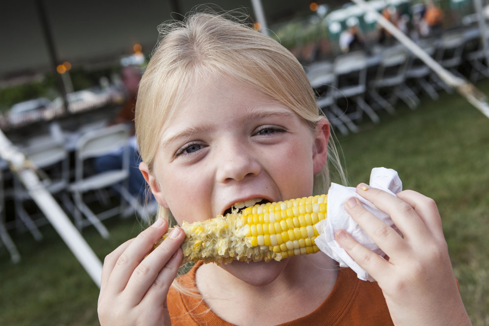 Lindsey Park, 9, of Cutchogue demonstrates the proper way to eat corn on the cob. (Credit: Katharine Schroeder)