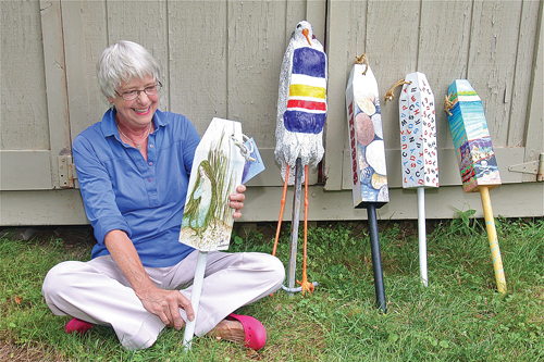 Artist Ann Sage of Greenport holds a buoy painted by artist Jada Rowland, her 'buoy bird' is next to her: the others are by Rich Feidler, John Wissemann and Nancy Wissemann Widrig. (Credit: Barbaraellen Koch)