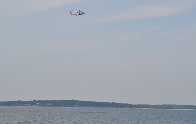 A U.S. Coast Guard helicopter searches between Robins Island and Nassau Point Monday afternoon. (Credit: Grant Parpan)