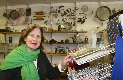 Arlene Marvin in her store Cookery Dock, which she has owned for 44 year at 132 Main Street in Greenport. Her customers tell her their favorite thing about the place are the antique cooking equipment she has on display on the side wall. (Credit: Barbaraellen Koch)