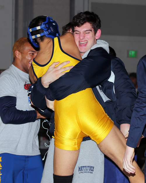 Bobby Becker of Mattituck celebrates with teammate Sal Loverde after defeating Joe Palma of Bayport-Blue Point in the 138-pound weight class. (Photo credit: Daniel De Mato)