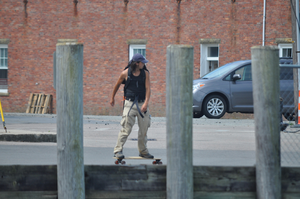 A skateboarder down by the ferry dock.
