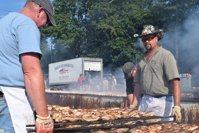 Cutchogue Fire Depatrment members Ben Benediktsson and Will Park (right) tend to the enormous grill. (Credit: Vera Chinese)
