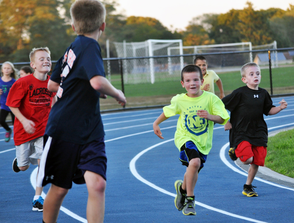 Members of the community, including these youngsters, took the first lap around the new Mattituck High School track together Friday evening. (Credit: Grant Parpan)