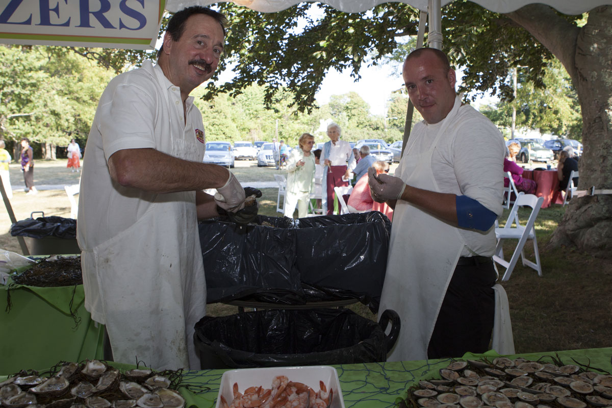 David Wells and Trevor Tolp hard at work opening clams and oysters. (Credit: Katharine Schroeder)