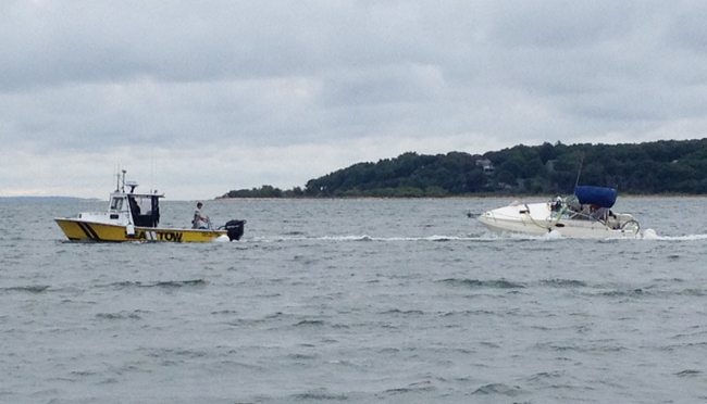 A Sea Tow boat tows the boat Saturday morning following the accident Friday night. (Credit: Sonja Reinholt Derr)