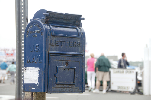 This small, antique — and still working — mailbox on Main Street in Greenport is slated to be removed and replaced with a more modern collection box up the road. Some who live in or work in the area aren’t happy about that. (Credit: Paul Squire)
