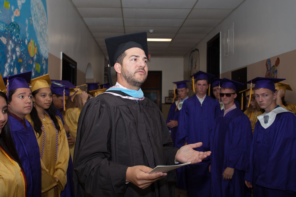 Principal Gary Kalish addresses the graduates in the hallway before the ceremony. (Credit: Katharine Schroeder)