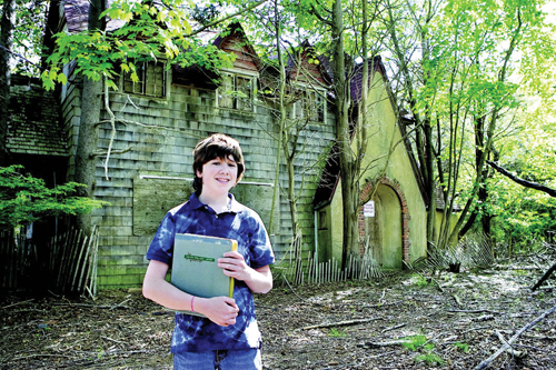 Ian Toy, at age 13 of Southold, in front of the house near Cedar Beach where Helen Keller may have spent the summer of 1936. (Credit: Suffolk Times, file)