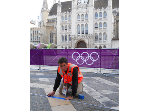 David Katz taping down a blue line, marking the marathon route for the 2012 London Olympic Games. (Credit: courtesy)