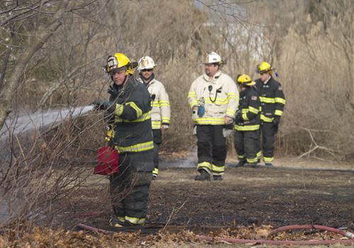 Mattituck firefighters douse the last of a small brush fire on Bay Avenue Thursday afternoon. (Credit: Paul Squire)