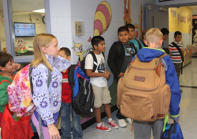 Southold Elementary School gather in the lobby before the official start of school Tuesday, some with very large bakpacks.