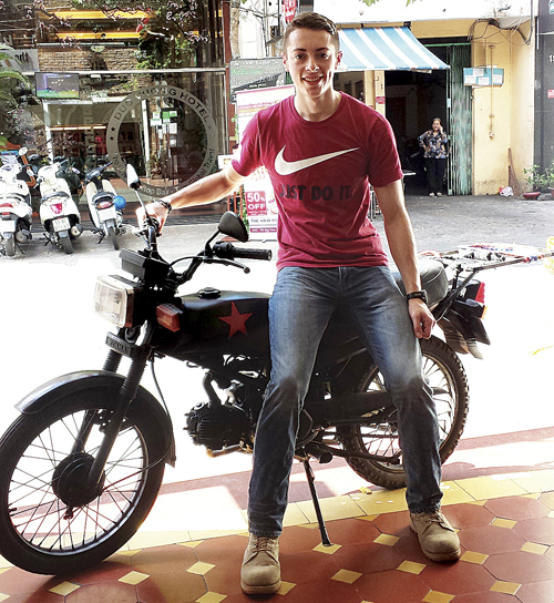 Mattituck's Ian Husak poses with his motorcycle shortly after purchasing it for $300 in Ho Chi Minh City. 