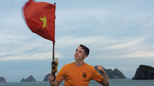 Ian Husak with the Vietnamese flag on a fishing boat in Ha Long Bay. (Credit: Ian Husak courtesy photos)