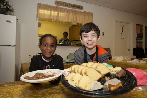 Darlene Shelby, 4, and Jonah Conologue, 7, getting dessert ready for a Martin Luther King Jr. Day celebration in Greenport. (Credit: Katharine Schroeder photos)