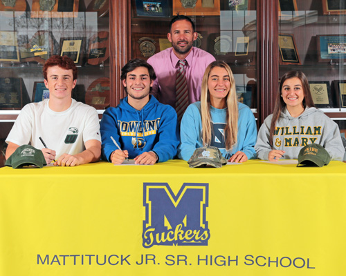 Mattituck athletic director Gregg Wormuth oversees a ceremony in which four players from the Mattituck/Greenport/Southold boys and girls lacrosse teams signed national letters of intent. The players, from left, are Tim Schmidt, Zach Holmes, Katie Hoeg and Audrey Hoeg. (Credit: Daniel De Mato)