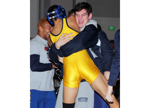 Adam Goode, left, one of Mattituck/Greenport's seven county champions, jumps into the arms of teammate Sal Loverde after winning the 195-pound final on Saturday night at Center Moriches High School. (Daniel De Mato photo)