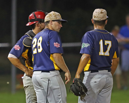 The North Fork Ospreys pitching coach Casey Schuermann #28 talks with Pitcher Brandon Alberto #17 and catcher Sean Buckhout #9 during the game against the Montauk Mustangs at Jean W. Cochran Park in Peconic on July 30, 2016.