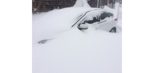 A car is buried in snow in Orient Tuesday. (Credit: Troy Gustavson)