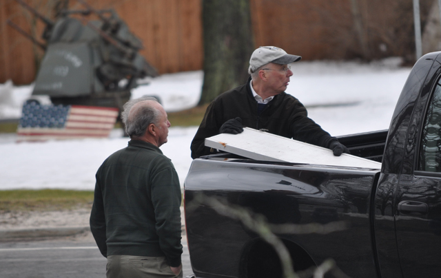 Pastor Jef Gamblee of First Universalist Church in Southold, with church member Peter Young of Southold, load the church sign into a pickup truck before driving it to a service at  Custer Institute. (Credit: Grant Parpan)