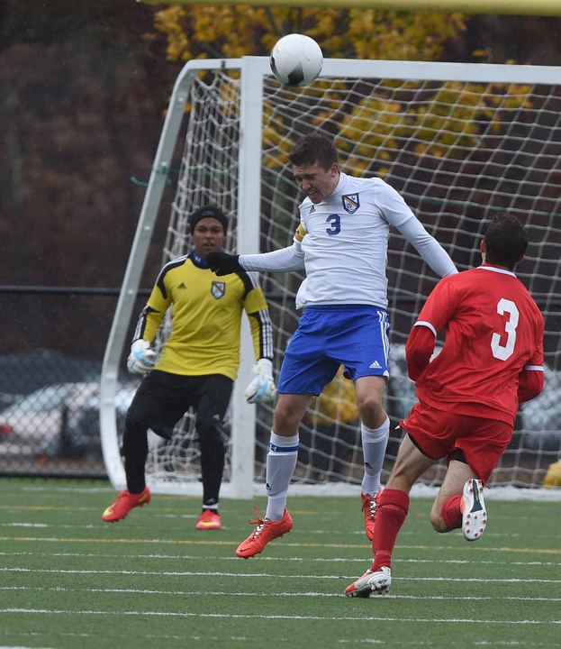 Kevin Williams on defense for Mattituck heads a ball away from his goal. (Credit: Robert O'Rourk)