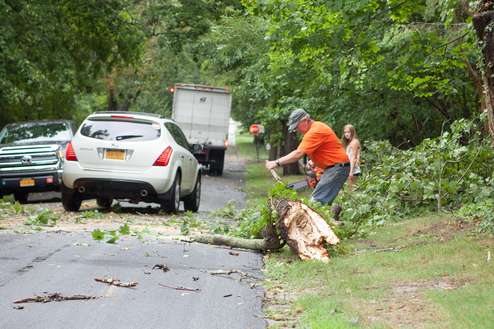 John Fudjinski clears a fallen tree on New Suffolk Avenue. (Credit: Katharine Schroeder)