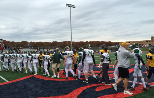 The Bishop McGann-Mercy and Shoreham-Wading River teams exchange handshakes following Saturday's playoff game at Miller Place High School. (Credit: Bob Liepa)