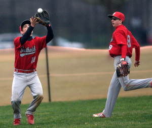 GARRET MEADE PHOTO | Southold's Anthony Esposito catching a fly ball in deep left field, with Shayne Johnson nearby.