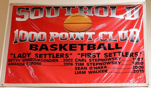 A banner hanging in the Southold High School gym lists four males who have scored 1,000 career points for the First Settlers. (Credit: Garret Meade, file)
