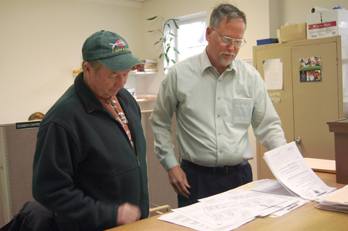 Town Trustee Jim King (left) reads over a permit application alongside Trustees president John Bredemeyer. After 20 years on the board, Mr. King will not seek re-election in November. (Credit: Cyndi Murray)