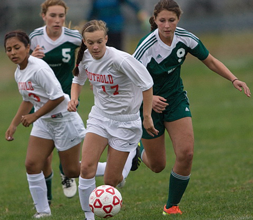 Southold/Greenport's Raeanne Berry dribbling forward while being followed by teammate Jasmine Fell and Bishop McGann-Mercy's Madeleine Joinnides (5) and Alexandra Hulse (9). (Credit: Garret Meade)