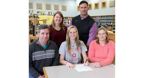Mattituck senior Nikki Zurawski, sitting between her parents John and Patricia, signed a national letter of intent for Sacred Heart University. Mattituck coach Malynda Nichol and athletic director Gregg Wormuth also participated in the signing ceremony. (Credit: Garret Meade)