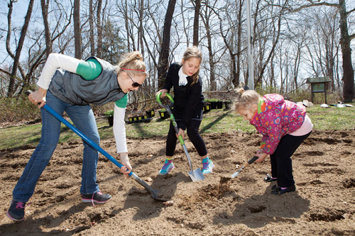 Group for the East End's Missy Weiss prepares soil with Victoria Witczak, 9, of Cutchogue, and her sister Julianna, 3, last weekend at Downs Farm Preserve in Cutchogue.