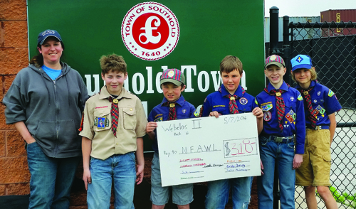 Southold Webelos with their donation 'check' for North Fork Animal Welfare League. From left: kennel manager Gabby Glantzman and scouts Stephen Clements, Jack Goscinski, Noah Berry, Matthew Molnar and Michael Lucak. Not pictured: Justin McGreevy, Brendan Mullen and Bobby Doering. (Credit: courtesy photo)