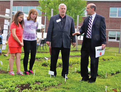 State Board of Regents member Roger Tilles (third from left) tours the Southold school garden with Superintendent David Gamberg and students Emiliann Palermo (left) and Bryanna Bay last year.