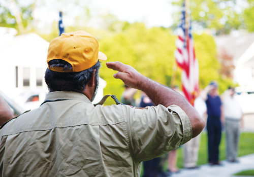 A man salutes the flag at a Southold Town Memorial Day parade. (Katharine Schroeder file)
