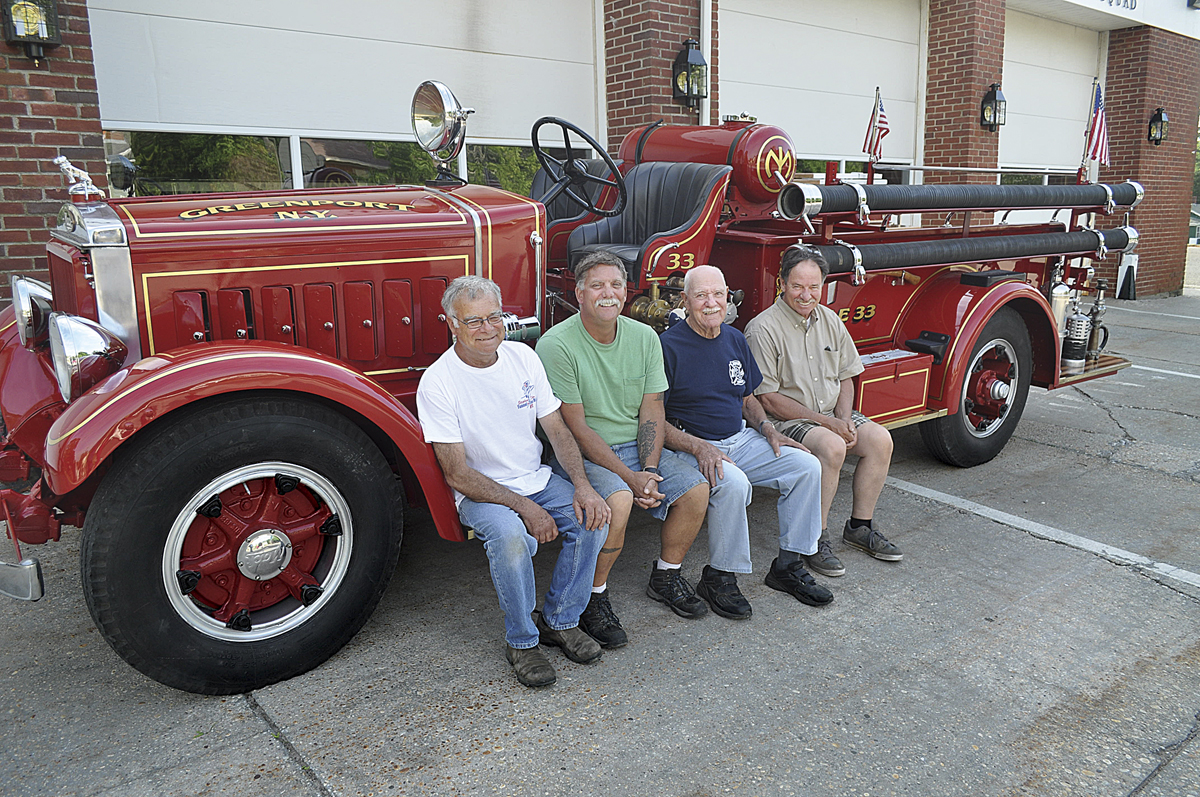 For the past 2 1/2 years, four Greenport Fire Department members have led the effort to restore the company's 1933 fire truck. Bob Jester (from left), John Grilli, George Capon and Charlie Hydell took it for its first test drive last month. (Credit: Grant Parpan)