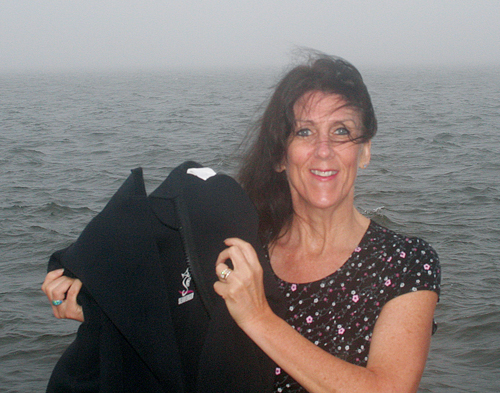 Joan Archard of Patchogue holds up her wetsuit Tuesday near Great South Bay, where she's been practicing for this weekend's swim from Greenport to Shelter Island (and maybe back). (Credit: Courtesy photo)