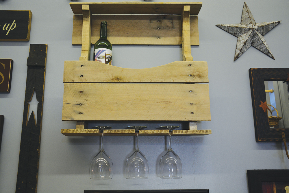 A wooden pallet, upcycled as a wall wine and glass holder.