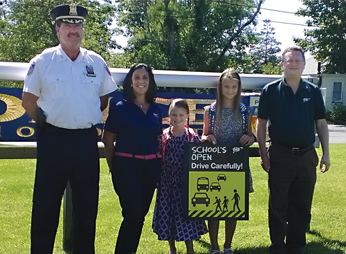 Southold police Chief Martin Flatley joined AAA traffic safety program coordinator Gerri DiSalvo and students Ciatlin and Mackenzie Jacobs and AAA community transportation specialist Christopher McBride to warn drivers to drive carefully. (Credit: AAA New York)