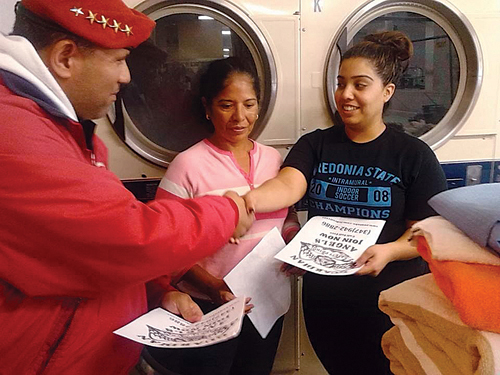 Guardian Angel Benjamin Garcia talks with two women at a Greenport laundromat Monday night. (Credit: Guardian Angels)