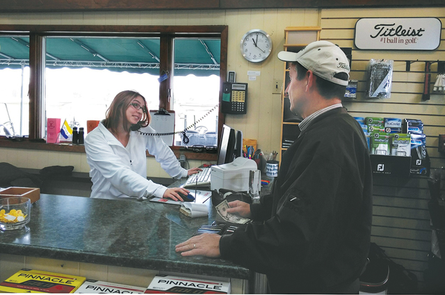 Kaitie Mazzaferro waits on customer Pete Kelly at the Island's End pro shop. (Credit: Jay Dempsey)