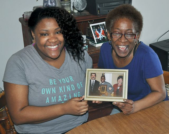 Michael Brown's sister, Karre Brown, and mother, Denise Wilson, hold a picture of the late Greenport resident from his time in high school. Mr. Brown, who had cerebral palsy, was killed in Northampton when his car was struck by a bus in 2010. A scholarship in his name will now benefit a local student with a disability. (Credit: Grant Parpan)