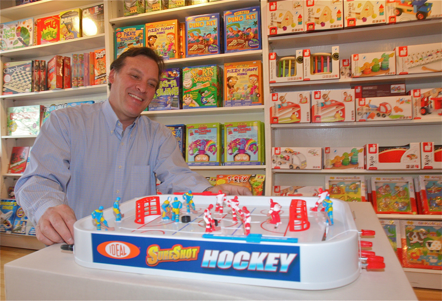 Love Lane Toys store owner Alex Dank demonstrates how the 'retro' toy Sure Shot Hockey works Monday afternoon. (Credit: Barbaraellen Koch)